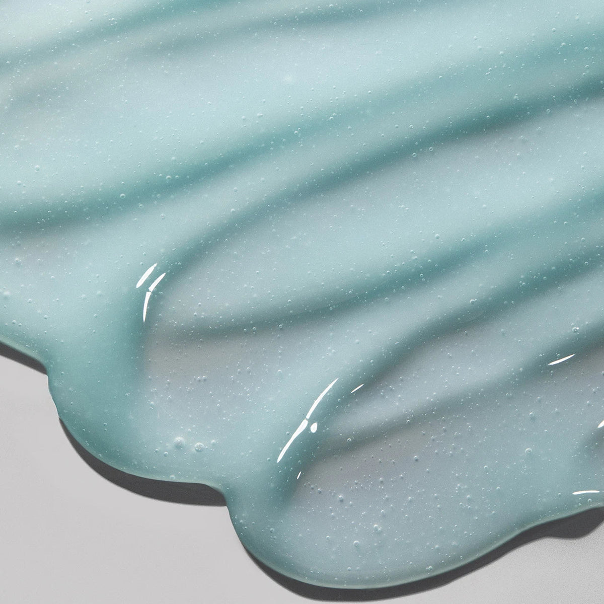 Close-up of a light blue, glossy substance on a gray background