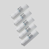 Five white cylindrical cosmetic tubes arranged diagonally on a light gray background. Each tube has a white cap, a white body with a silver-gray label, and a thin blue accent line near the top of the label.