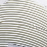 A close-up texture shot of a thick, creamy off-white cosmetic cream with horizontal ridges.