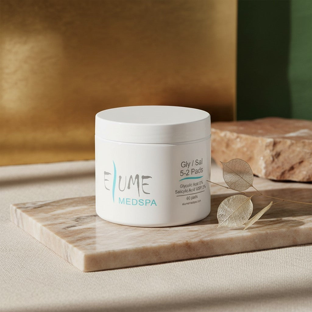 Elume Medspa Gly/Sal 5-2 exfoliating pads in a white jar on a marble surface with a dried leaf.