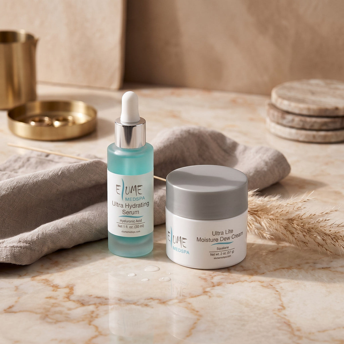 Elume Medspa Ultra Hydrating Bundle with hyaluronic acid serum and lightweight moisture dew cream on marble surface