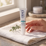 Elume Med Spa Obagi Retinol 1.0 anti-aging serum tube resting on a white cloth with a sprig of eucalyptus