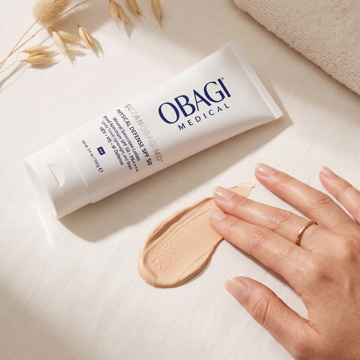 Elume Medspa SUZANOBAGIMD Tinted Physical Defense SPF 50 mineral sunscreen tube with a swatch of tinted cream